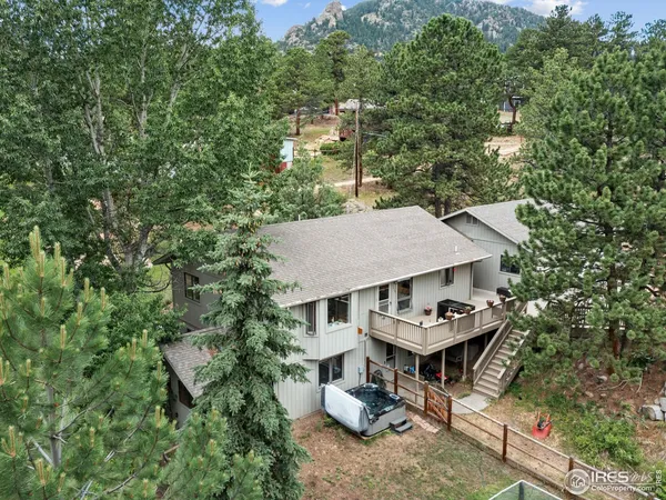 an aerial view of a house with swimming pool and large trees