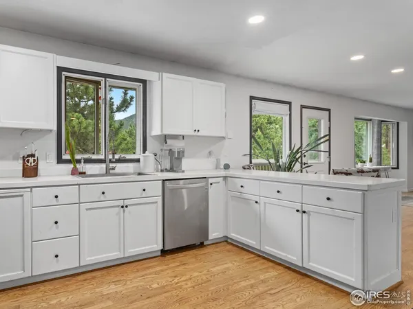 a kitchen with granite countertop a sink window and cabinets