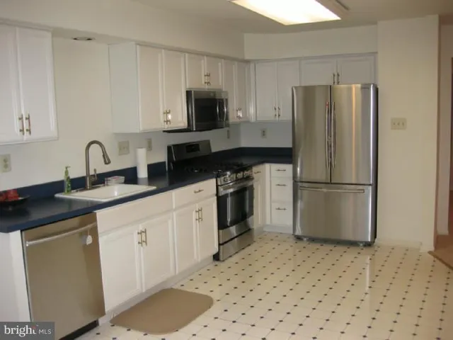 a kitchen with stainless steel appliances a refrigerator sink and microwave