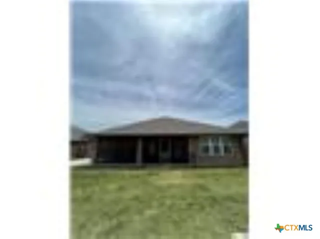 a view of a house with a large window and a yard
