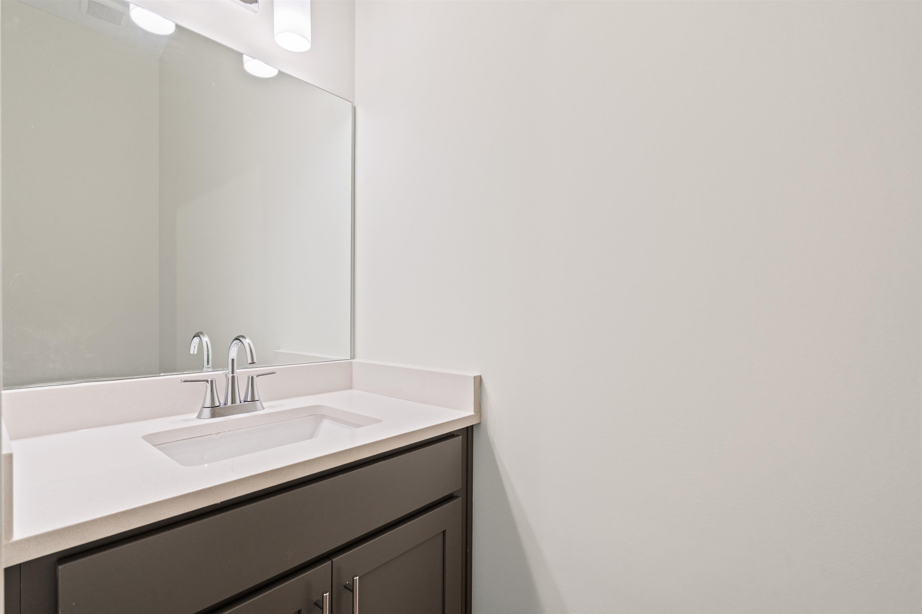 5666 Pleasant Pk Place Arlington, TN 38002 - Photo 10 of 27 Bathroom vanity featuring a white countertop with an integrated sink, brushed nickel faucet, and dark wood-finish cabinetry