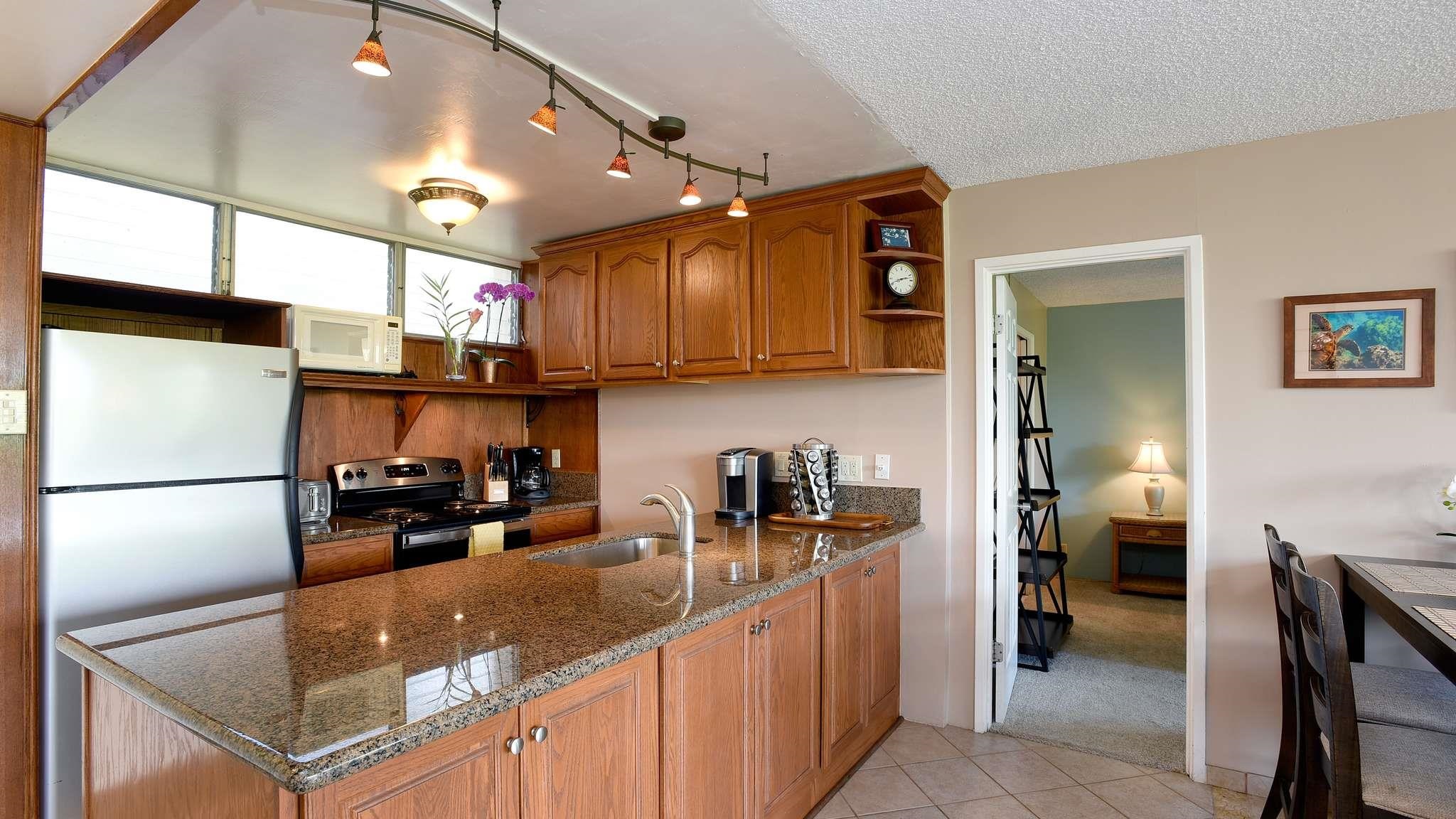 2619 South Kihei Road, Unit 309A Kihei, HI 96753 - Photo 12 of 41 a kitchen with refrigerator and cabinets