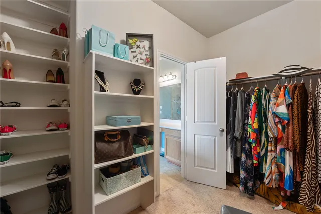 a view of walk in closet with clothes and shoes