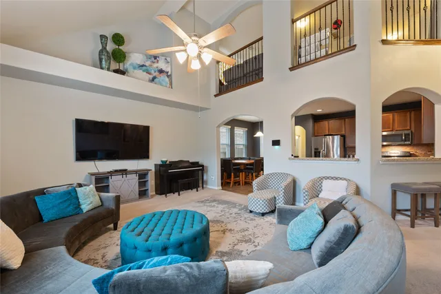 a living room with furniture a flat screen tv and kitchen view