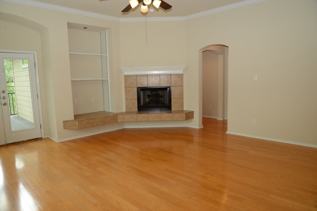 138 Chestnut Court Georgetown, TX 78633 - Photo 19 of 25 Hardwood floors complement a cozy tile fireplace and built-in shelving.