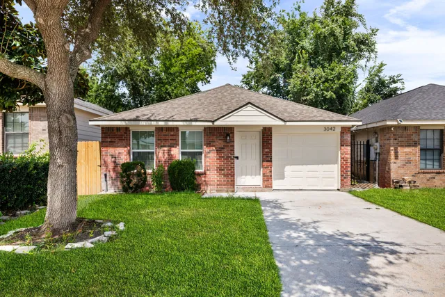 a front view of a house with a yard and trees