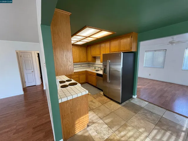 a kitchen with stainless steel appliances granite countertop a refrigerator a stove and a sink