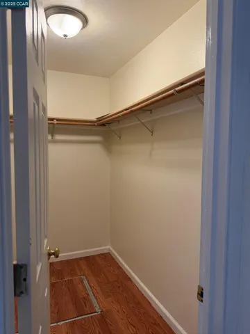 a view of a room with wooden floor and small hallway