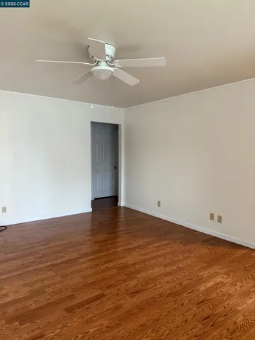 a view of an empty room with wooden floor