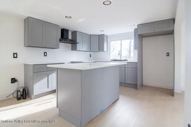 a kitchen with stainless steel appliances a sink a stove a microwave a refrigerator and cabinets