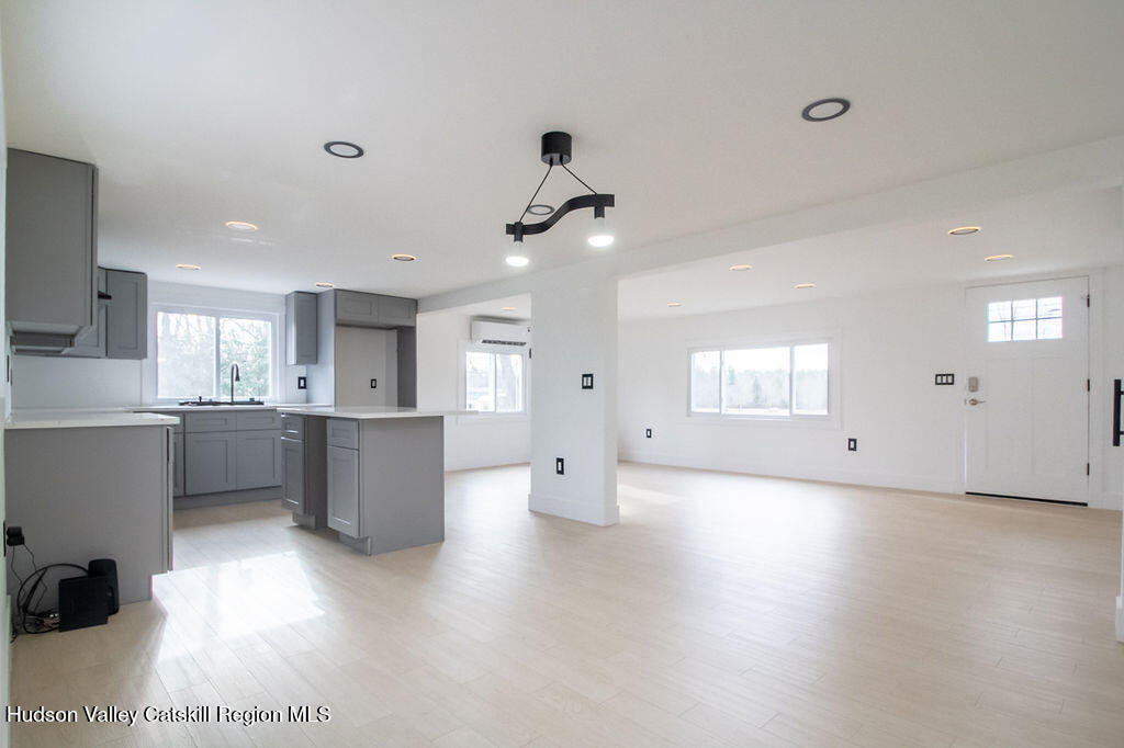1732 Ulster Heights Road Ellenville, NY 12428 - Photo 22 of 40 a view of an empty room and kitchen with a sink wooden floor and windows