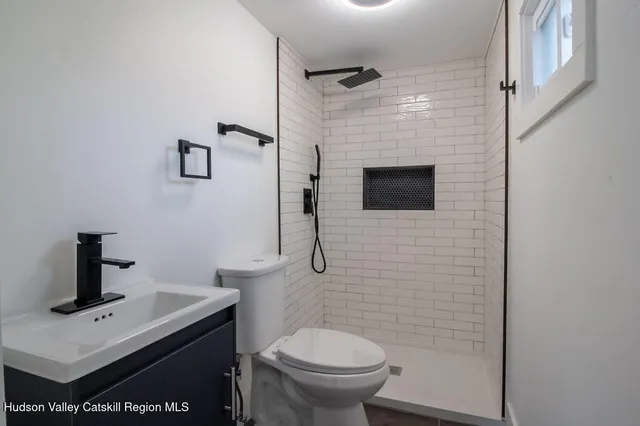 a bathroom with a toilet a sink and mirror