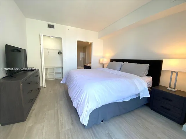 a bedroom with a bed and a flat screen tv