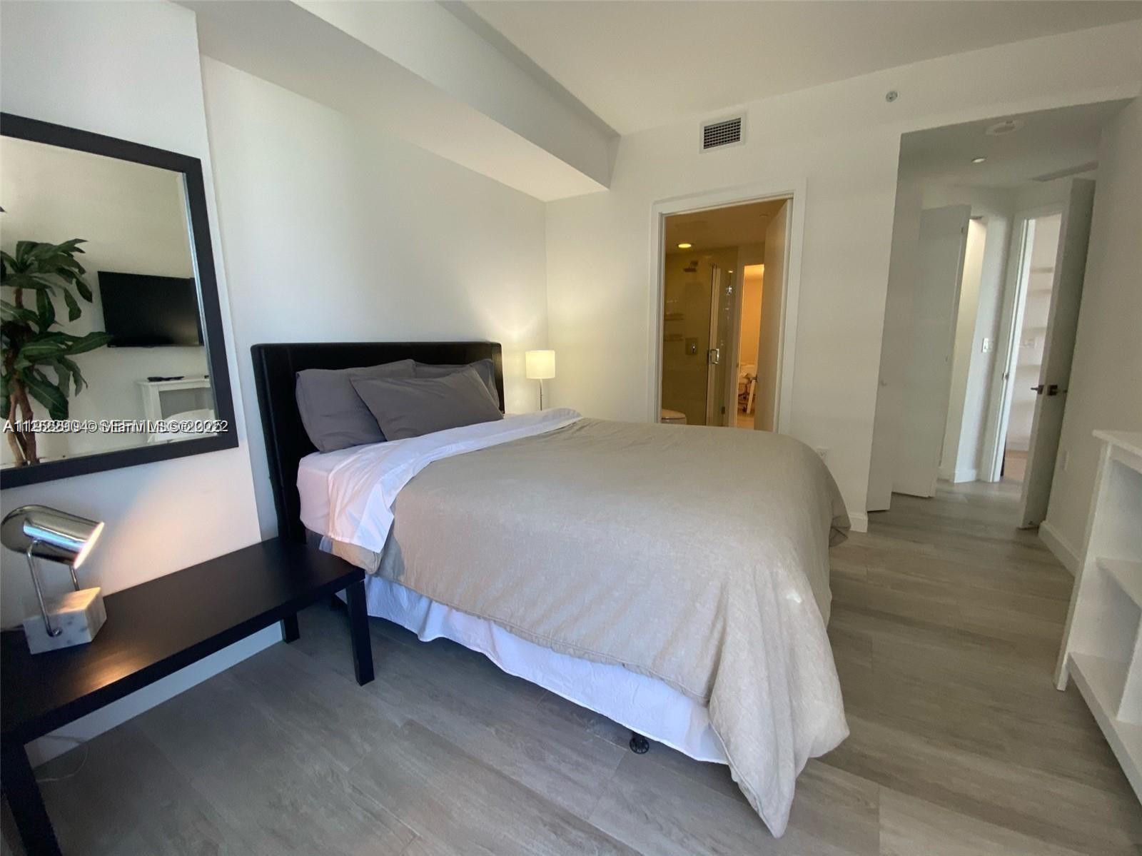 55 Southwest 9th Street, Unit 3001 Miami, FL 33130 - Photo 13 of 28 a bedroom with a bed and a flat tv screen on wall