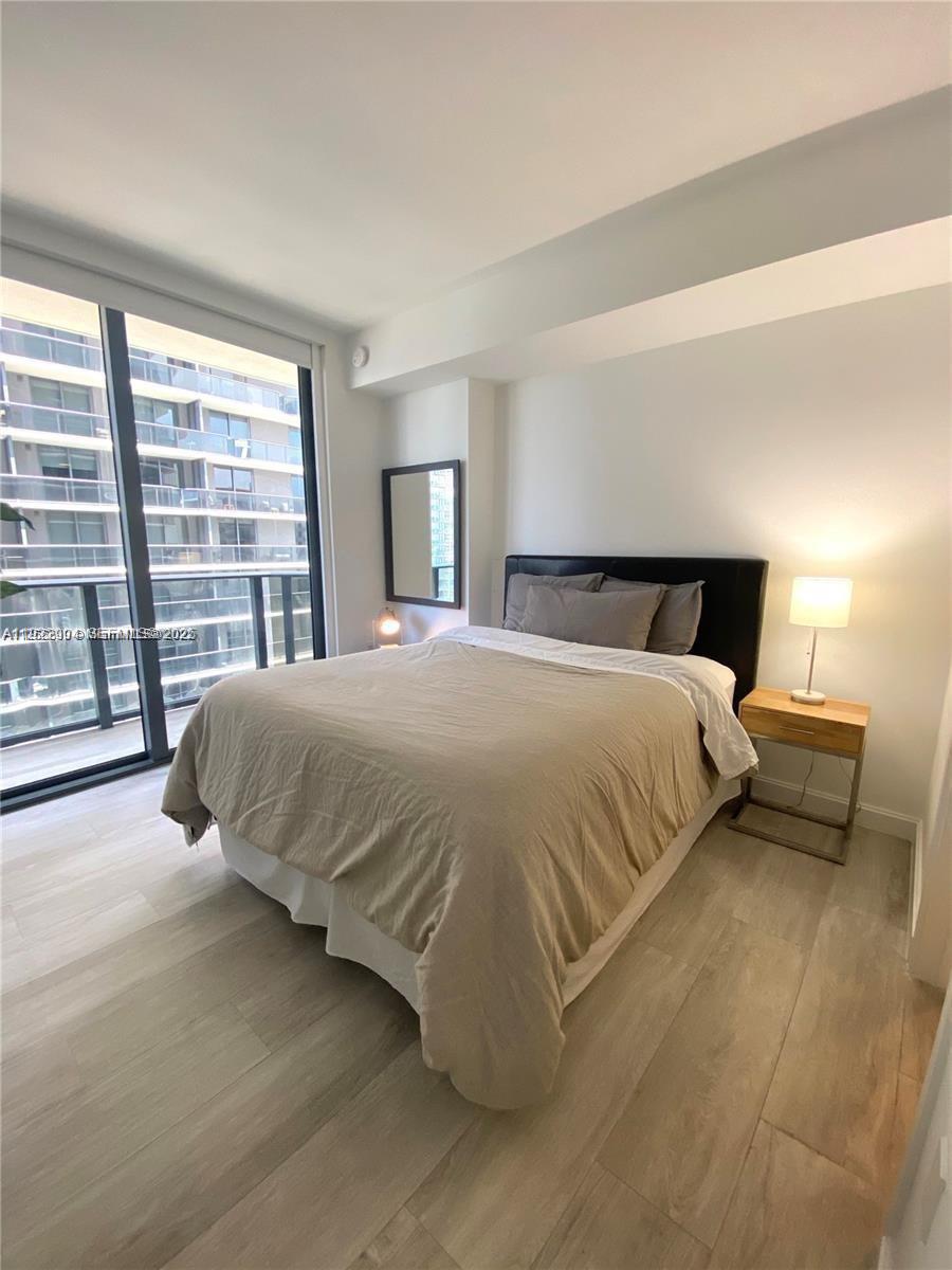 55 Southwest 9th Street, Unit 3001 Miami, FL 33130 - Photo 14 of 28 a bedroom with a bed and glass walk in closet