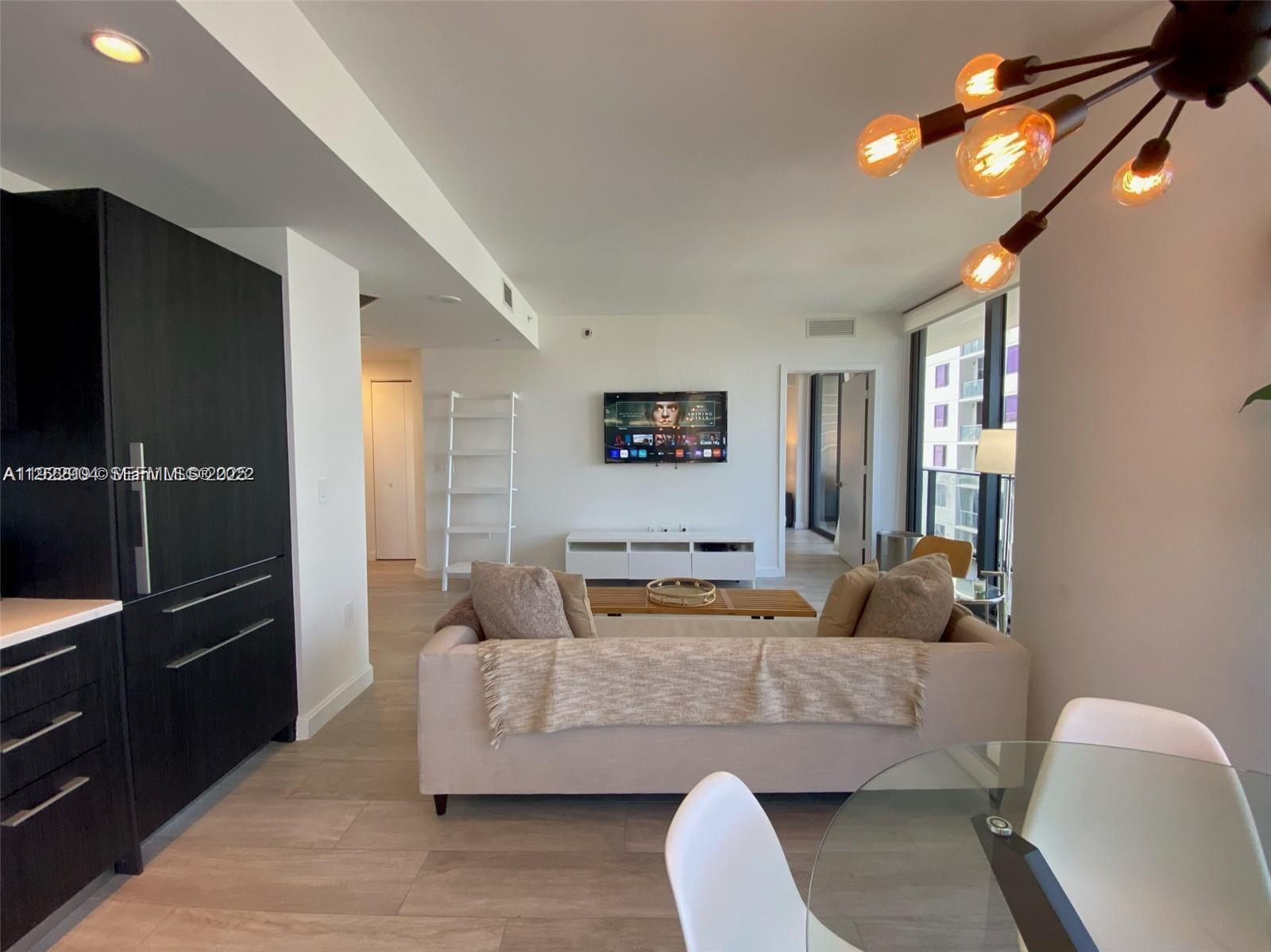 55 Southwest 9th Street, Unit 3001 Miami, FL 33130 - Photo 4 of 28 a living room with furniture and a flat screen tv