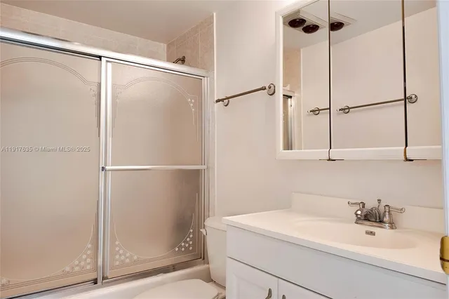 a bathroom with a shower sink vanity and a mirror