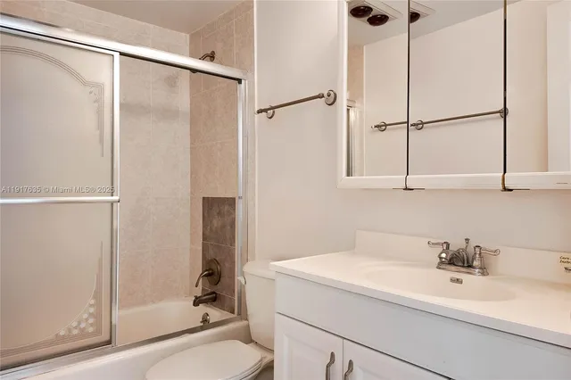 a bathroom with a sink and mirror with shower