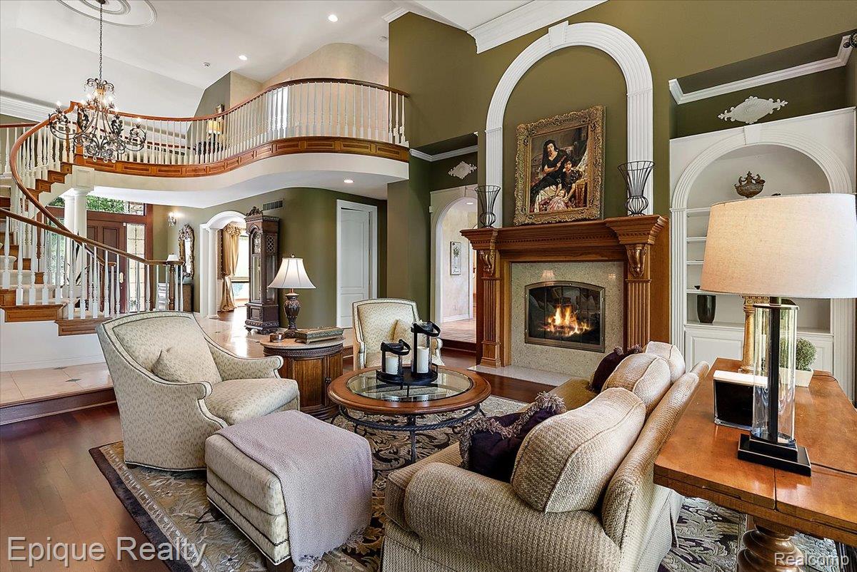 7662 Devins Ridge Clarkston, MI 48348 - Photo 28 of 81 Elegant double-height living area featuring a grand curved staircase with white balusters and wood handrails