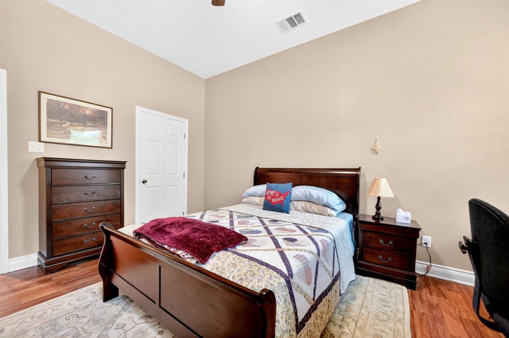 5230 Esquire Estates Road Mabank, TX 75156 - Photo 17 of 39 Vaulted ceiling bedroom with wood-finish flooring, light tan walls, and white trim