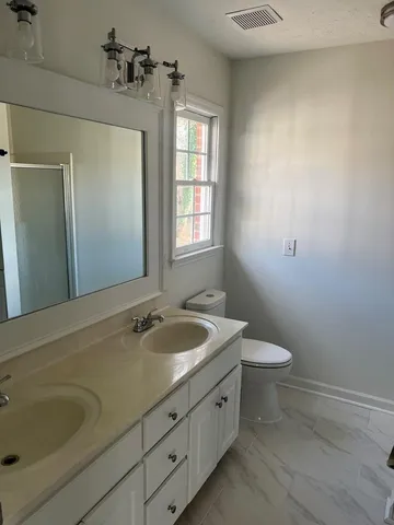 a bathroom with a sink and mirror with toilet