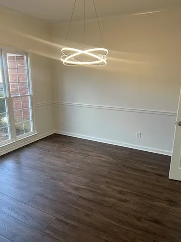 a view of a room with wooden floor and window