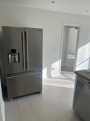a view of kitchen with refrigerator and cabinet