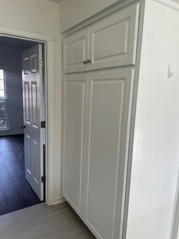 a view of a closet area with wooden floor