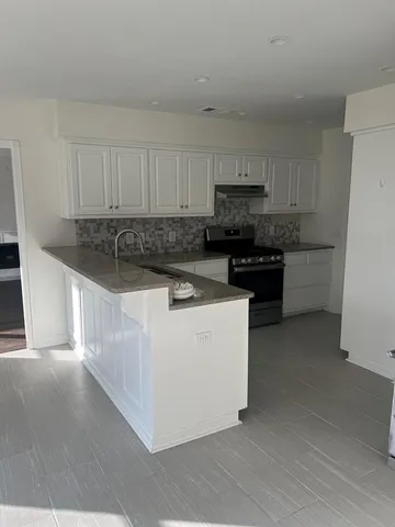 a kitchen with stainless steel appliances granite countertop a stove a sink and a refrigerator