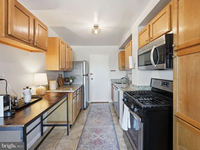 a kitchen with stainless steel appliances a stove a sink dishwasher and cabinets with wooden floor