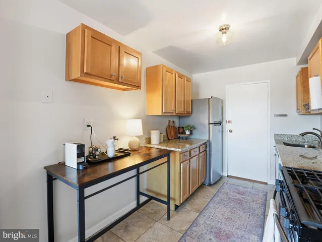a kitchen with stainless steel appliances granite countertop a stove refrigerator sink and cabinets