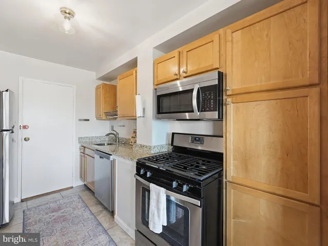 a kitchen with stainless steel appliances granite countertop a refrigerator stove top oven a sink and dishwasher