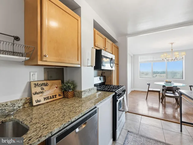 a kitchen with stainless steel appliances granite countertop a sink a stove and a refrigerator
