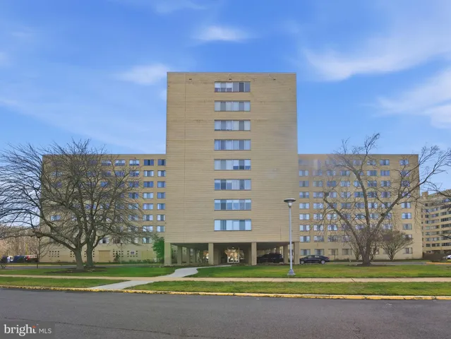 a view of a tall building next to a yard