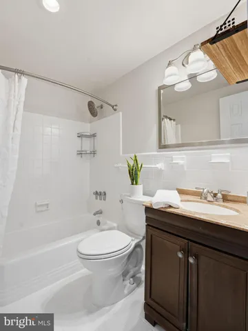 a bathroom with a granite countertop sink a toilet and shower