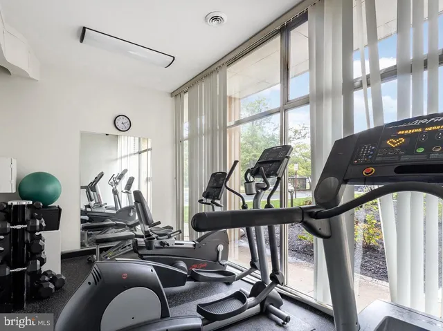 a room with gym equipment and large windows