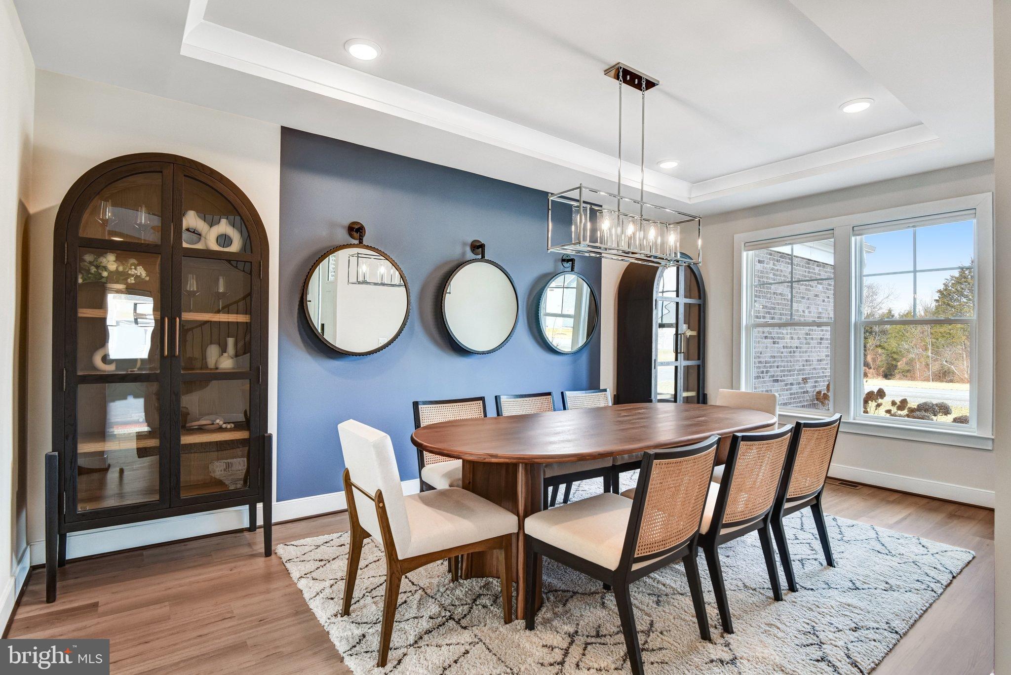 43199 Dogan Rdg Place Centreville, VA 20120 - Photo 19 of 86 a dining room with wooden floor a chandelier a wooden table and chairs