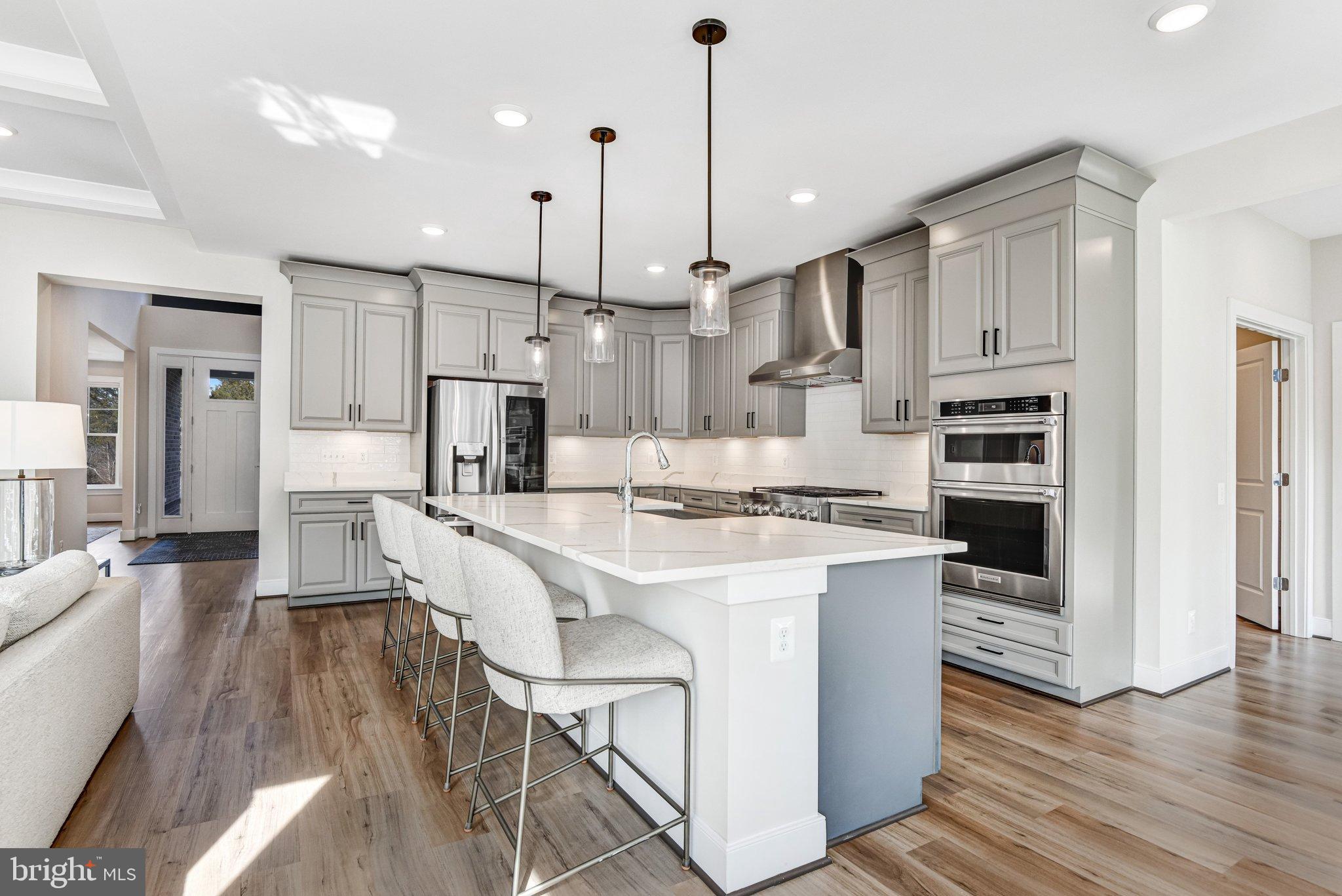 43199 Dogan Rdg Place Centreville, VA 20120 - Photo 2 of 86 a large kitchen with kitchen island white cabinets and stainless steel appliances