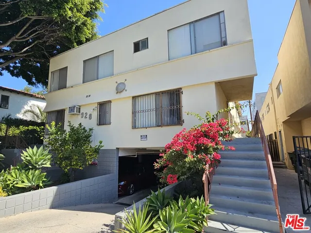 a front view of a house with a flower garden