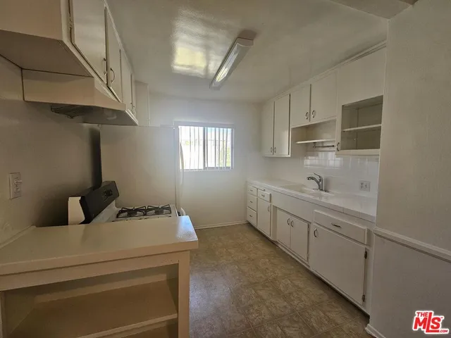 a kitchen with a sink cabinets and window