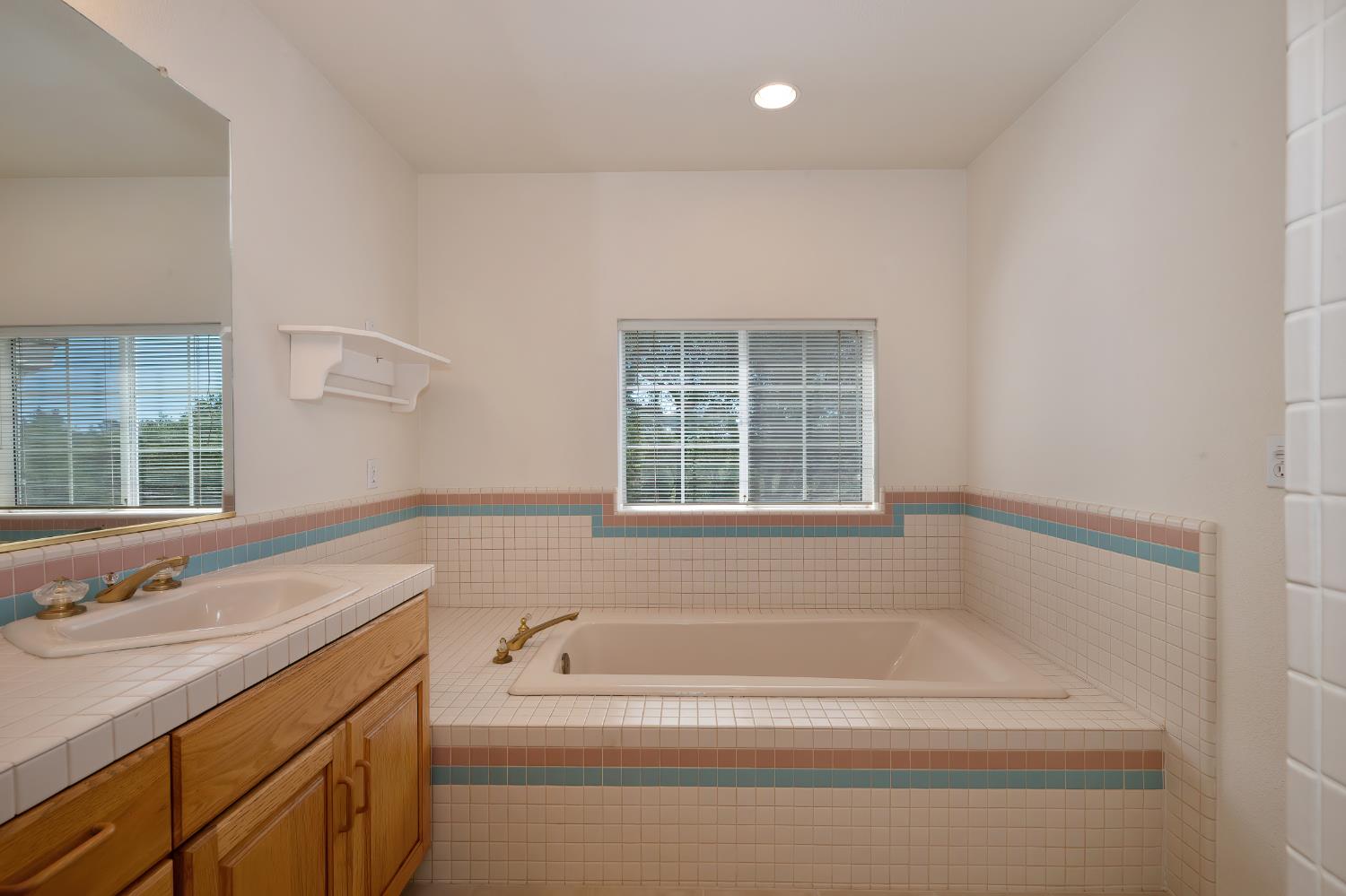 3730 Kimo Way Auburn, CA 95602 - Photo 36 of 75 a bathroom with a granite countertop sink and a bathtub