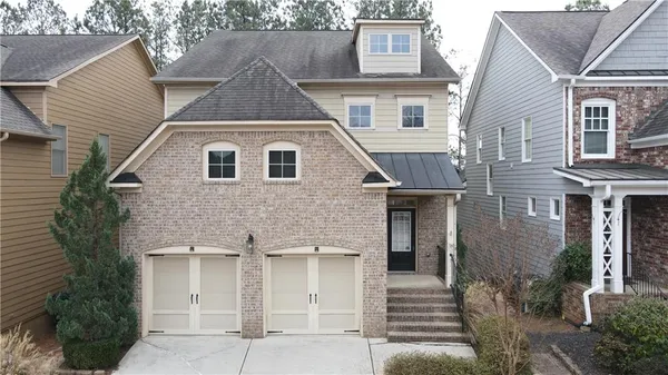 a view of a house with a yard and large tree