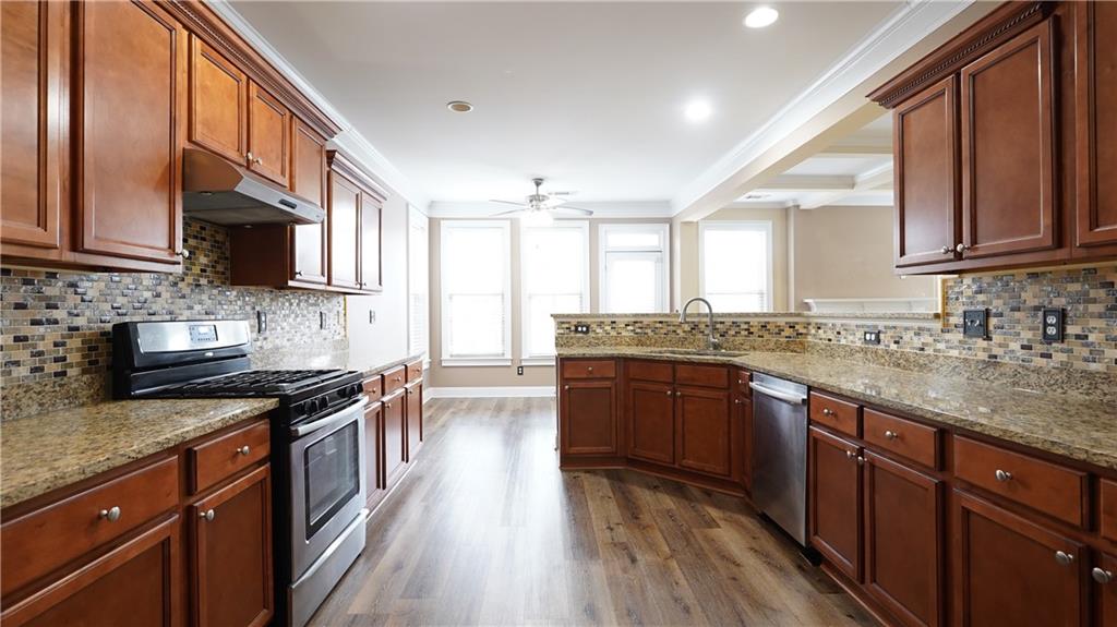 548 Myrtle Trace Lane Suwanee, GA 30024 - Photo 27 of 74 a kitchen with stainless steel appliances granite countertop wooden cabinets a sink and a stove