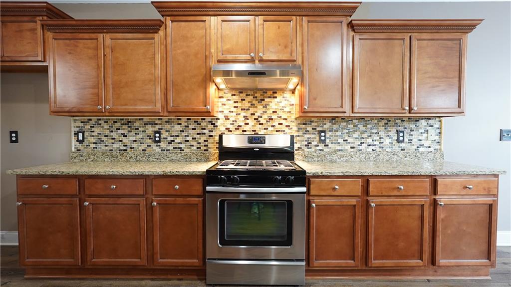 548 Myrtle Trace Lane Suwanee, GA 30024 - Photo 28 of 74 a kitchen with granite countertop a stove and cabinets