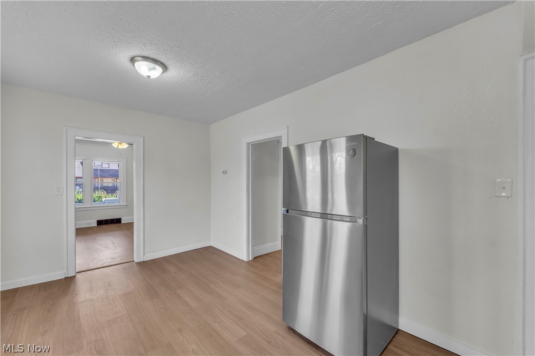 12905 Watterson Avenue Cleveland, OH 44105 - Photo 10 of 30 Kitchen featuring freestanding refrigerator, a textured ceiling, and light wood finished floors