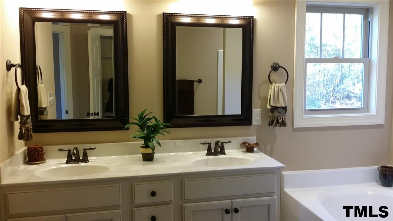 665 Tilghman Road Coats, NC 27521 - Photo 14 of 25 a bathroom with double vanity sinks and a mirror