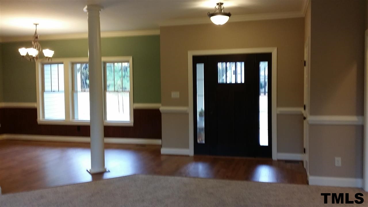 665 Tilghman Road Coats, NC 27521 - Photo 6 of 25 a view of a hallway with wooden floor and front door