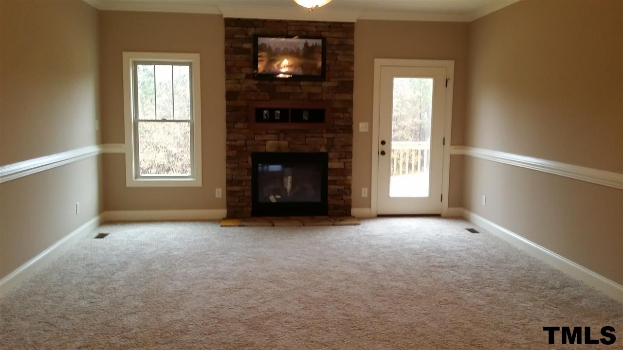 665 Tilghman Road Coats, NC 27521 - Photo 8 of 25 an empty room with windows and fireplace