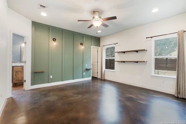 a view of a livingroom with a ceiling fan window and a kitchen