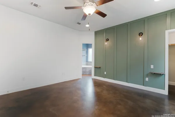 an empty room with closet and a chandelier fan